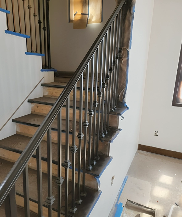 Staircase With Wood Staining and Metal Railings in Progress