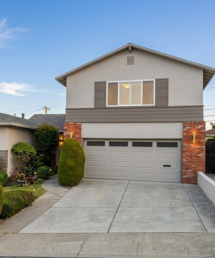 Modern Two-Story House with Neatly Trimmed Hedges and Driveway