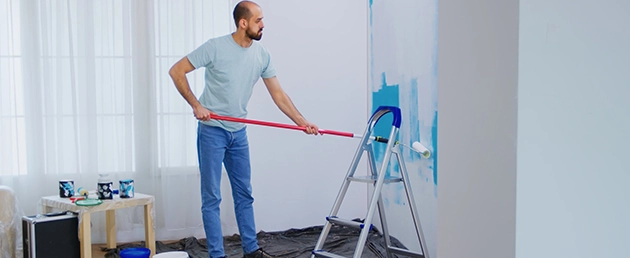 Man Painting Wall with Roller, Working as Painting Contractor San Jose
